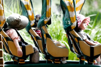 A couple of kids riding on top of a roller coaster