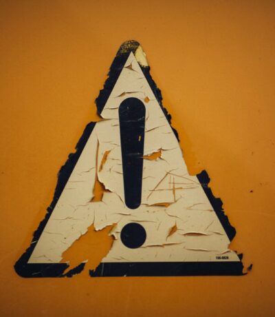 a triangle shaped sign on a yellow wall